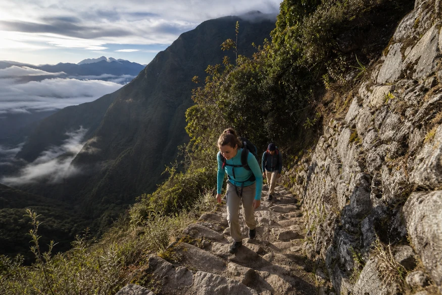 Hikers climbing steep stone steps on the Classic Inca Trail in Peru