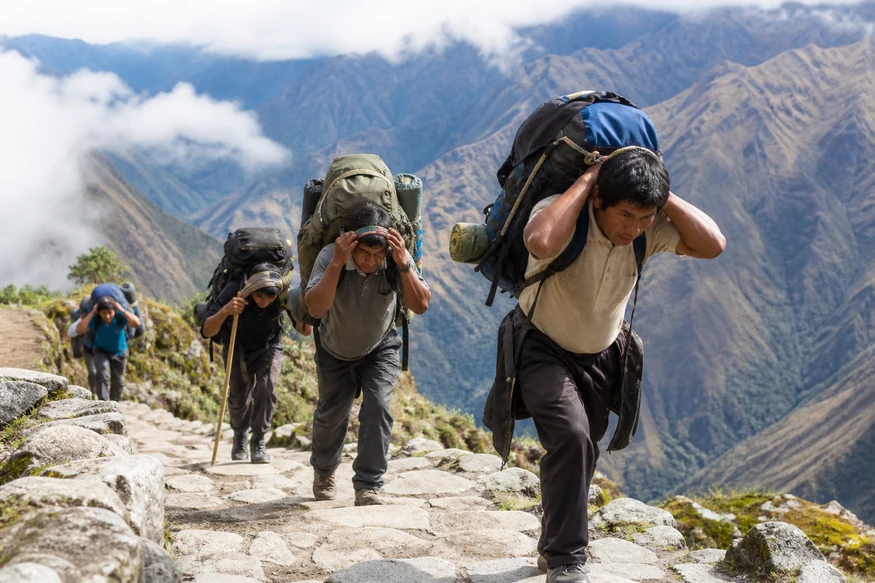 Peruvian porters transporting expedition equipment on the Inca Trail