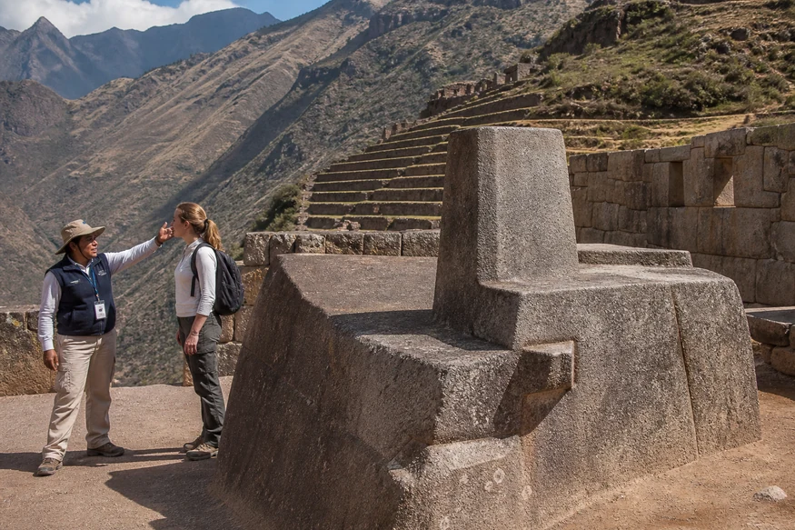 Guide explaining ceremonial stonework in the Intihuatana sector of Pisac ruins